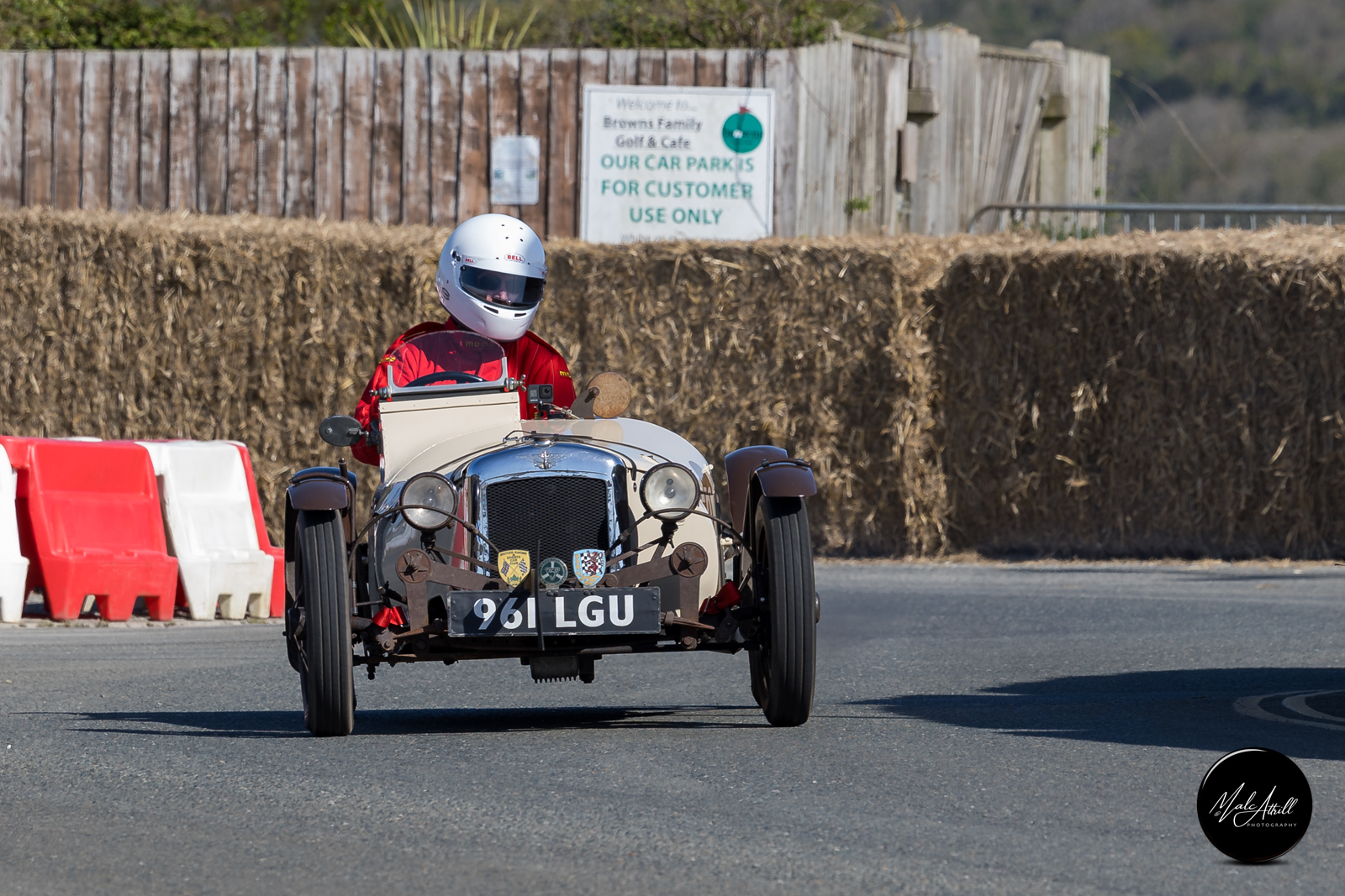 Pre-war open-wheel special '961 LGU' at speed between straw bales