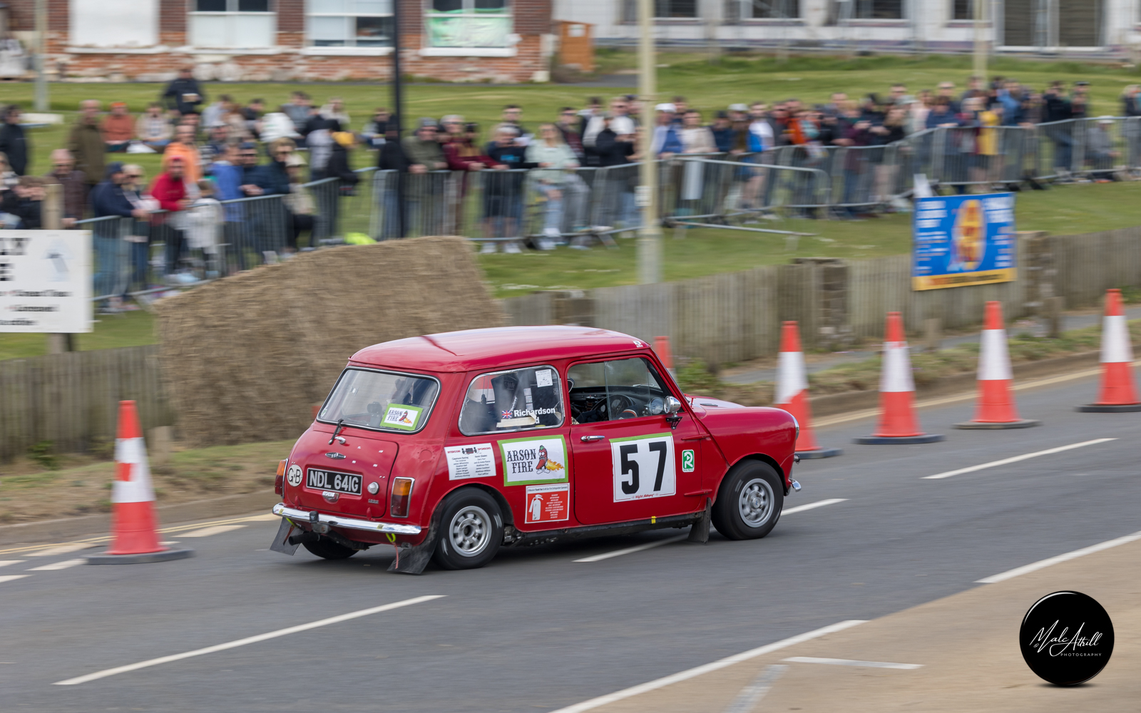 Classic red Mini number 57 sliding past the seafront crowds
