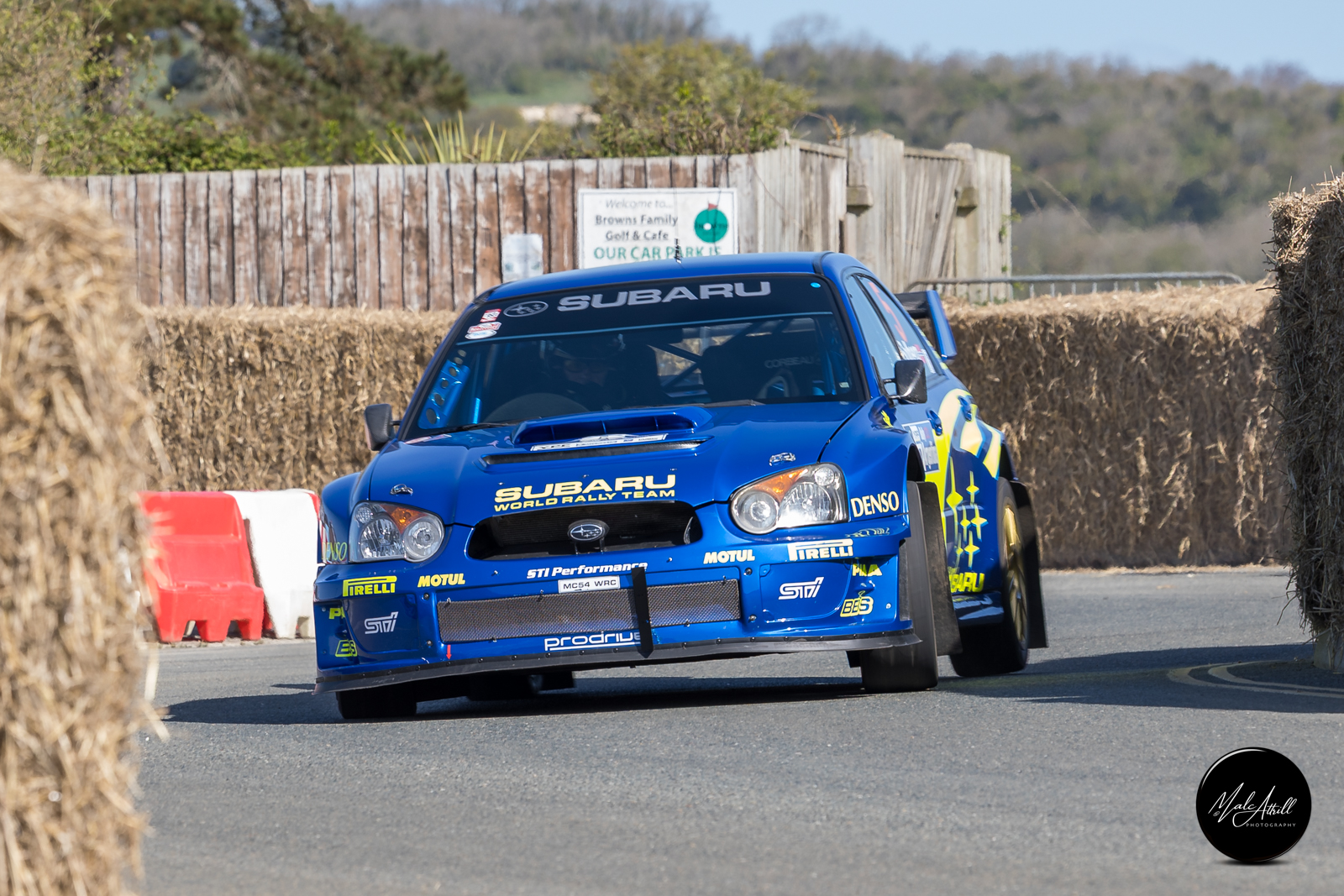 Subaru Impreza World Rally Team car on full opposite lock past the bales